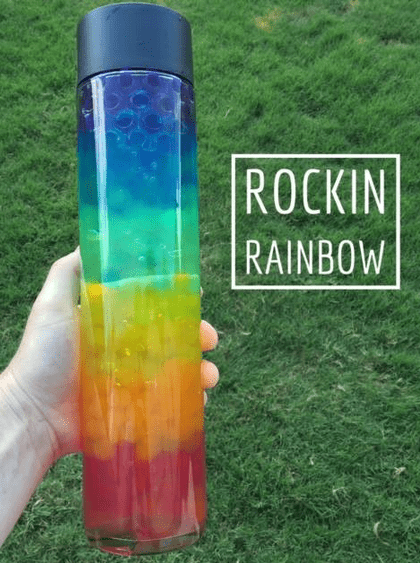 A sensory bottle with layers of water beads in order of the rainbow