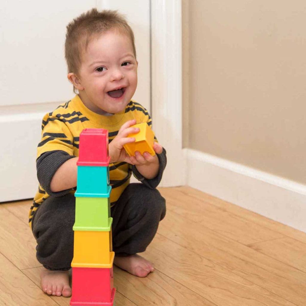 A young boy sorting and stacking colorful blocks