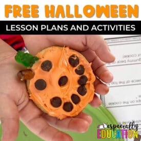 A child holding a pumpkin decorated cookie made using the visual recipe provided in the free Halloween themed lesson plans