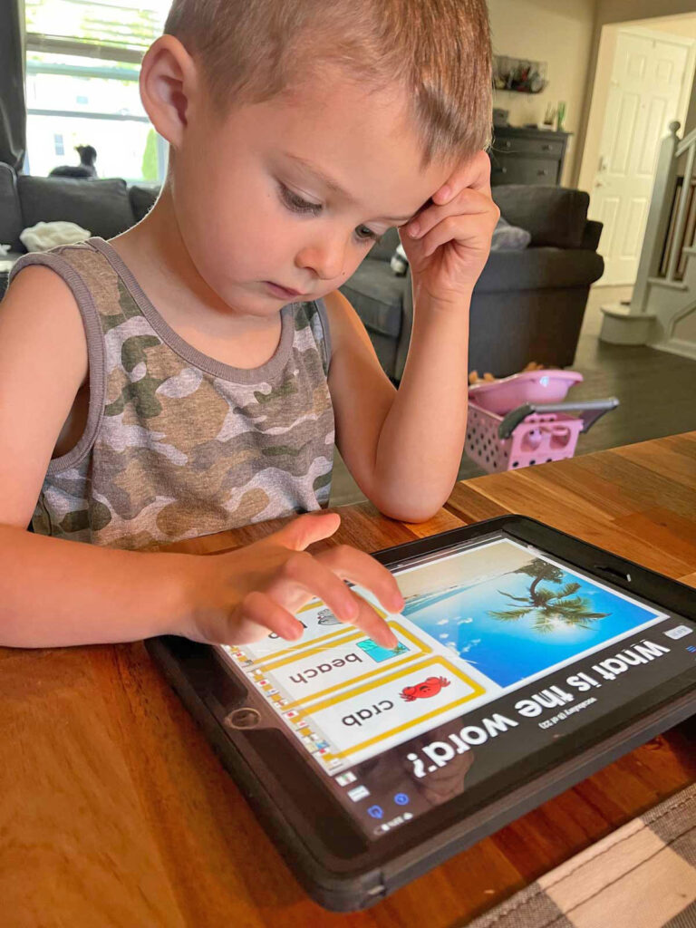 Author's son sitting at a desk working on a digital worksheet on an iPad.