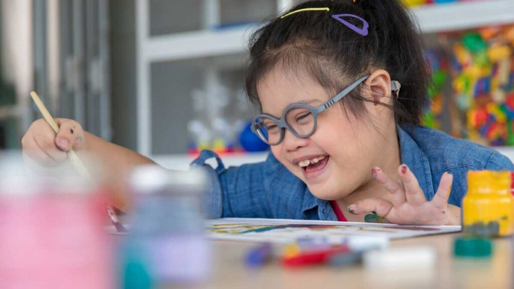Student painting during a hands-on classroom activity for Mother’s Day in a special education setting