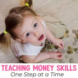 Small girl playing on the floor with coins from a jar